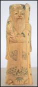 A 19th century Chinese / Japanese carved okimono bone figurine of an elder having a character seal