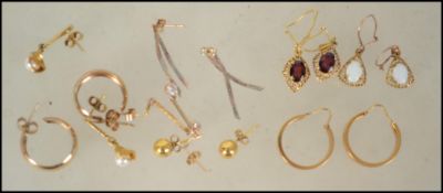 8 pairs of 9ct gold earrings in various styles some with inset stones together with a small 9ct gold