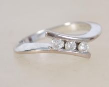 An 18 ct white gold cross over ring with 3 diamond