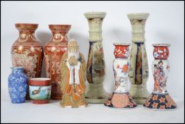 A collection of Chinese / Japanese ceramics to include Imari candlesticks, figurine of an elder.