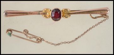 A 9ct gold Edwardian bar brooch having a central faceted red stone to center and c clasp pin back