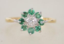 An 18ct gold emerald and diamond ring having cluster head with central diamond and emerald surround,