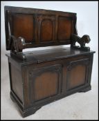 A mid 20th century oak Monks bench having carved e