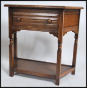 An Ercol oak console hall table being raised on turned legs with shaped cabinet top having reeded