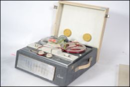 A vintage mid 20th century reel to reel player by Civic with tape to the inside.
