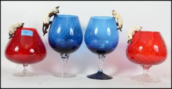 A set of 4 red and blue large brandy glasses of bulbous form complete with the adorning Beswick Cats