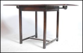 An Ercol beach and elm wood drop leaf dining table raised on squared legs with central stretcher