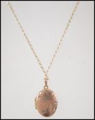 A 9ct gold fancy curb link necklace chain having a spring hoop clasp and a 9ct gold locket