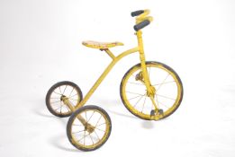 A vintage mid 20th century child's trike possibly by Triang with a yellow paint finish.