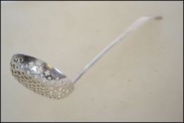 A Georgian silver hallmarked sugar spoon / shaker dating to 1822, London assay mark with makers