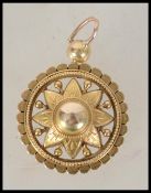 An 18ct gold necklace pendant having a central star flower with roundel to centre, a bevelled rope