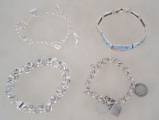 A collection of 4 silver bracelets to include double hoop with lobster clasp, charm bracelet with