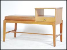 A 1970's teak wood telephone table being raised on