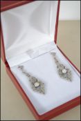 A pair of silver and marcasite Art Deco style earrings set with a central opal. Drop 4cms. 8.4g.