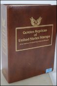 An album of seventy - four Golden Replicas of United States Stamps / First Day Of Issue proof
