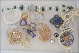 A quantity of costume jewellery to include brooches, a Timex watch and pearl necklaces together with
