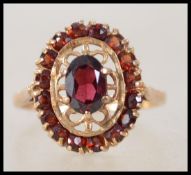 A vintage  hallmarked 9ct gold and garnet cluster ring. Hallmarked for Birmingham 1975. Weight 3.5g.
