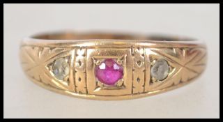 An 18ct gold, ruby and diamond 3 stone ladies ring. The gold shank with chased edgings surrounding