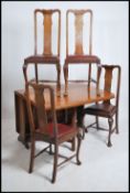 A 1930's large solid oak drop leaf dining table being raised on gate legs together with a set of 4