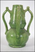 A Ch Brannan art pottery 4 handled green glazed vase. Of baluster form, with green glazed being