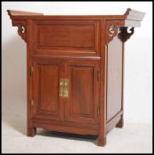A Chinese hardwood ' alter ' style cabinet having hinged top with cupboards doors to the front.