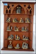 A mahogany wall mounted display stand complete with fine pewter and gilded metal figurines from