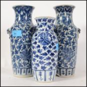 A large pair of Chinese blue and white Kang-xi type tall vases with fu dog masks to the sides