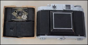 A vintage Ensign Midget camera together with another similar and a Mamiya Six slr camera in