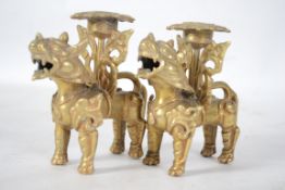 A pair of vintage early 20th century brass  candlesticks in the form of temple dogs / Dogs of Fu