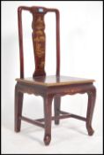 A 20th century Chinese lacquered Chinoiserie hall chair having a heavily gilt decorated with