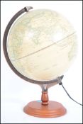 A 20th century desk top terrestrial globe being raised on a terraced wooden base