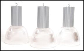 A set of 4 contemporary Industrial large factory pendant lights having half moon plastic shades with