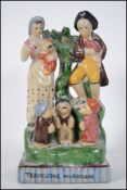 An early 20th century Staffordshire flatback figurine entitled ' Travelling Musicians ' being raised