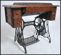 An early 20th century Singer Sewing machine table. The inset machine on oak top raised over the cast