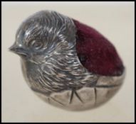 A silver hallmarked miniature pin cushion in the f