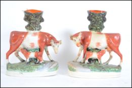 A pair of Victorian Staffordshire flatback spill vase figurines having naturalistic plinth bases