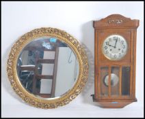 A vintage mid 20th century oak cased eight day wall clock together with a gilt framed mirror.