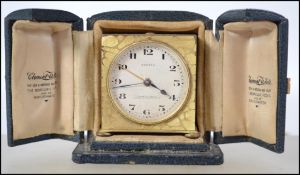 A early 20th century brass Zenith travel alarm clock, keyless wind movement striking on a bell,