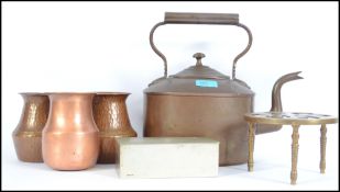 A collection of vintage brass and copper wares dating to the 20th century to include a large kettle,