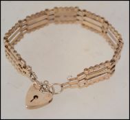 A 9ct / 375 marked bracelet of mesh linked for complete with heart padlock and safety chain. Total