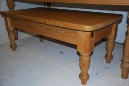 A large country pine antique style coffee occasional tabe raised on turned legs with fitted frieze