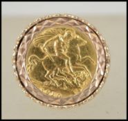 A 9ct gold sovereign ring. The half sovereign with Edward VII coin dated 1910 set within large