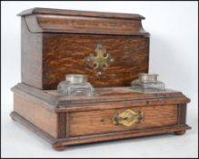 A Victorian oak and brass bound desk tidy having twin glass inkwells with pull out drawer. To the