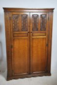 A good quality ipswitch oak linen fold double wardrobe having plinth base with double full length