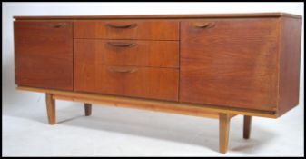 A retro Danish style teak wood sideboard raised on tapered legs with cupboards and drawers. Finished