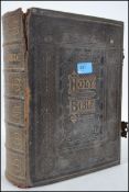 A large 19th century leather and gilt tooled Bible complete with clasps having illustrated details