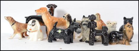 A collection of ceramic dog figurines to include scottie dogs, spaniels, terriers, retriever etc.
