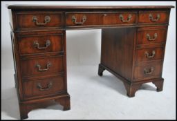 A Georgian style mahogany twin pedestal office writing desk raised on bracket feet with a series