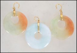 A demi Parure jade and 24ct gold earring and necklace pendant set. The white mutton fat jade roundel