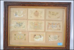 A framed and glazed collection of World War One silk postcards, each of decorative form being